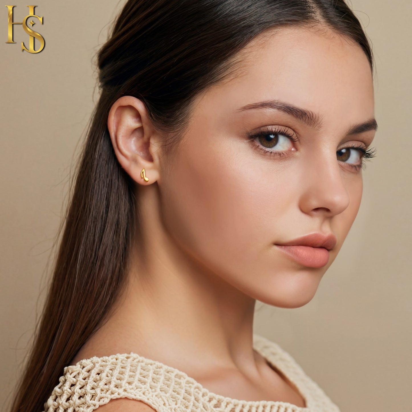 A small, gold-plated stud earring shaped like a musical eighth note, worn on the ear of a model looking over her shoulder.