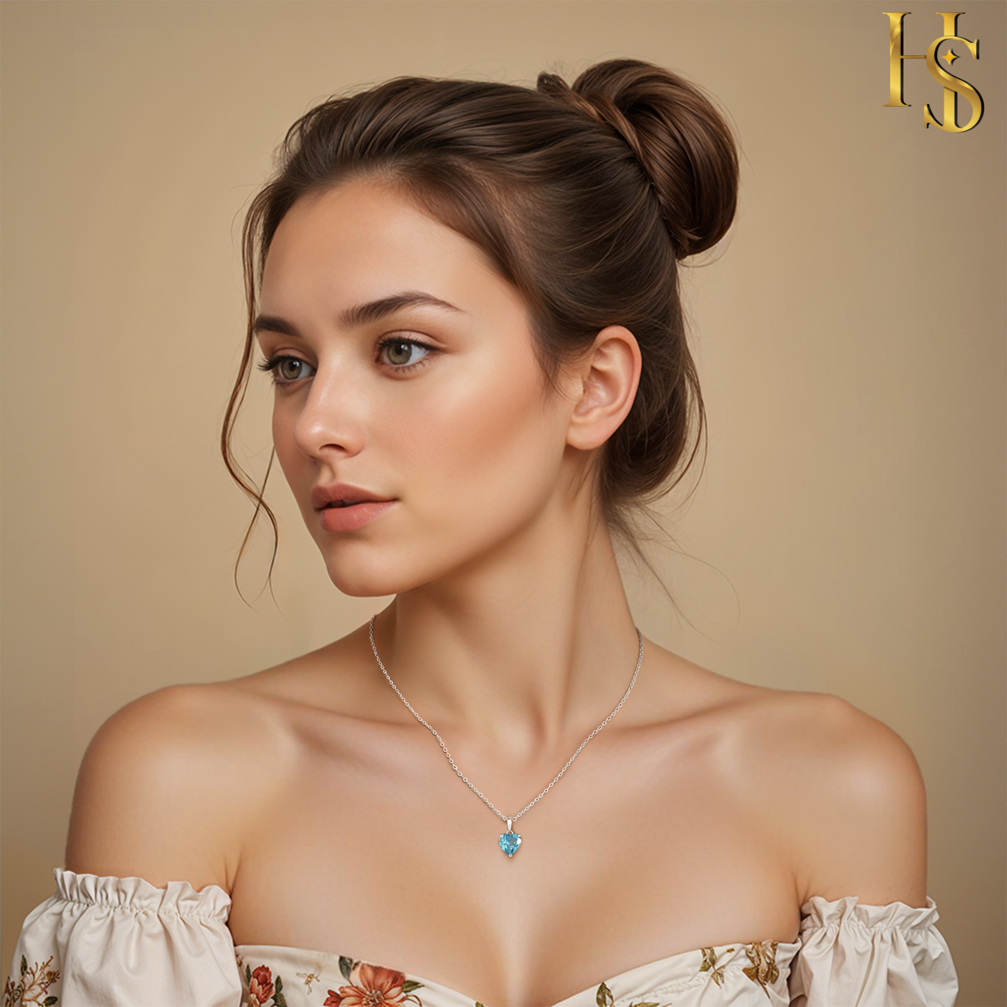 A sterling silver pendant necklace with a blue, heart-shaped solitaire stone is worn on the neck of a model against a beige background.