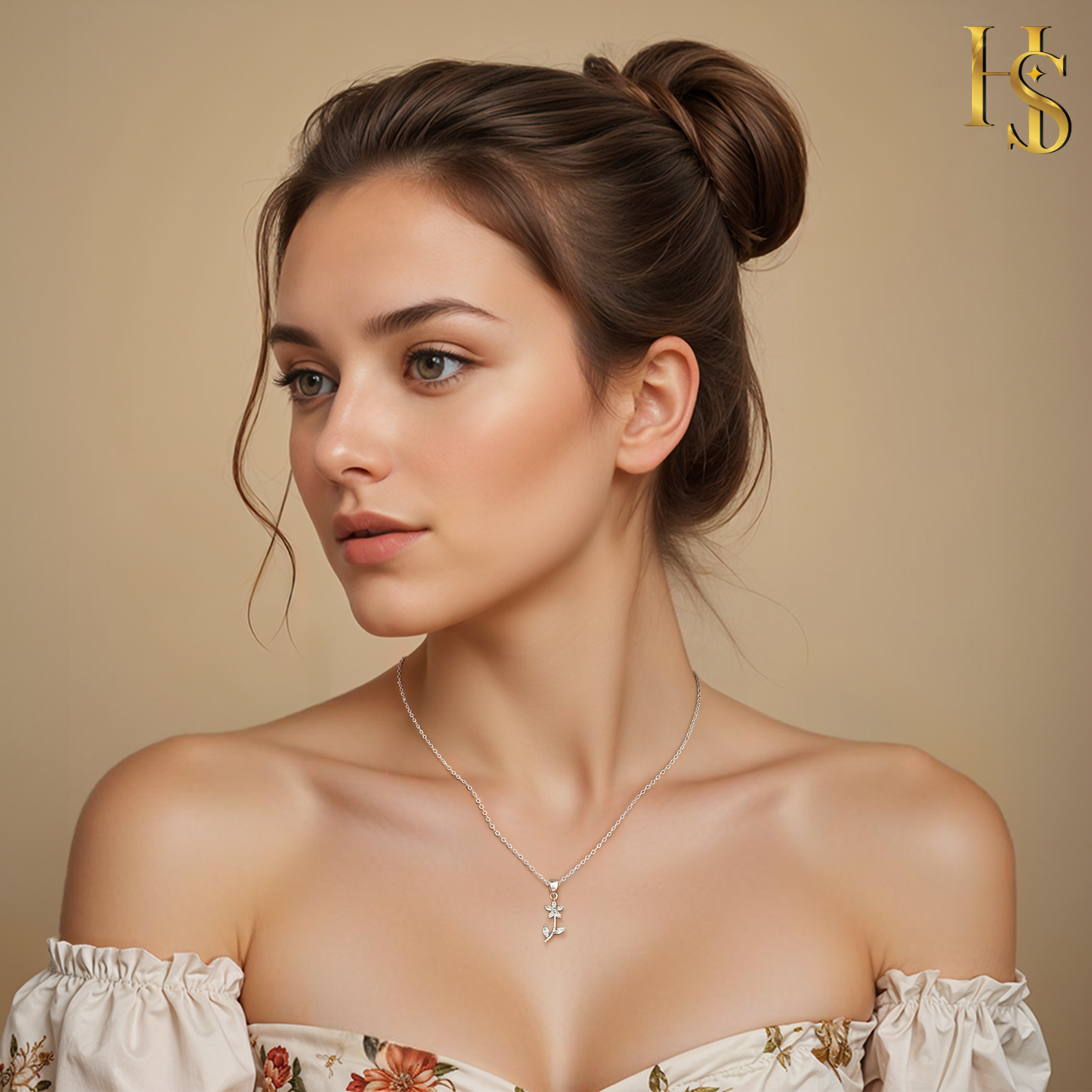 A sterling silver pendant necklace with a small flower and an anchor motif, both set with American diamonds, worn on the neck of a model.