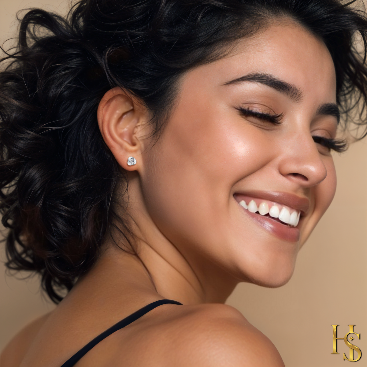 A woman smiles while wearing sterling silver stud earrings with a central American diamond in a swirling knot design.