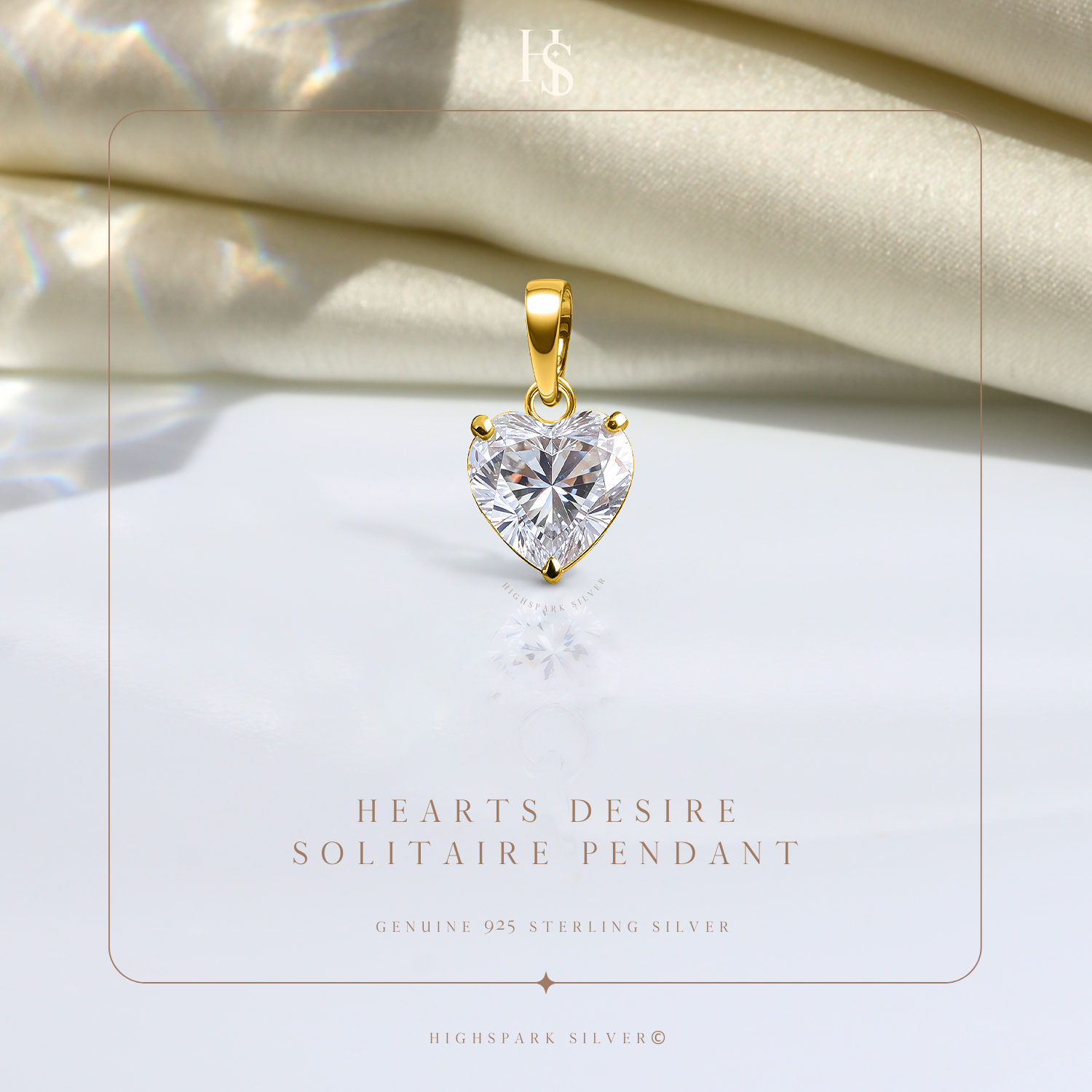 A heart-shaped solitaire American diamond pendant with a three-prong setting and gold-plated bail, styled on a reflective white surface.