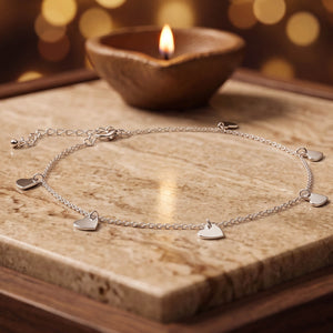 925 silver heart charm chain anklet, beside a lit diya - anklets category