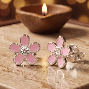Pink enamel flower stud earrings in 925 silver with a cubic zirconia centre, for kids, beside a lit diya - enamel category