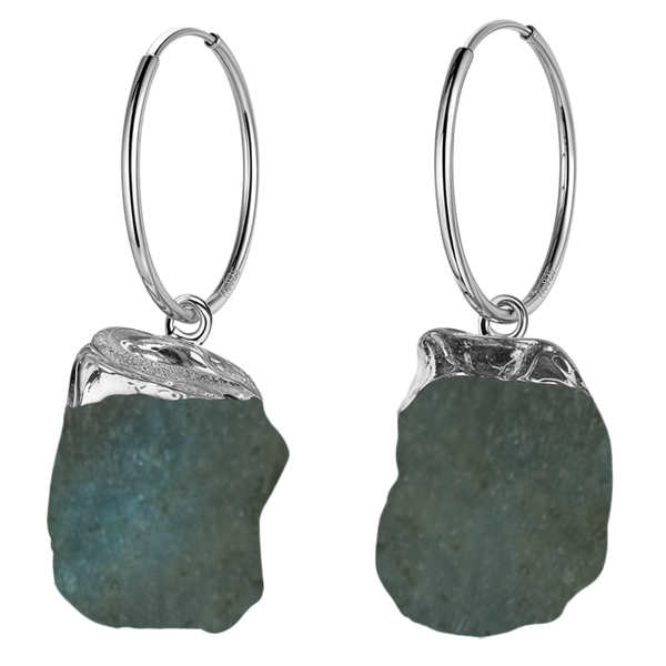 A pair of sterling silver hoop earrings with a raw, uncut labradorite gemstone charm hanging from each hoop on a plain white background.