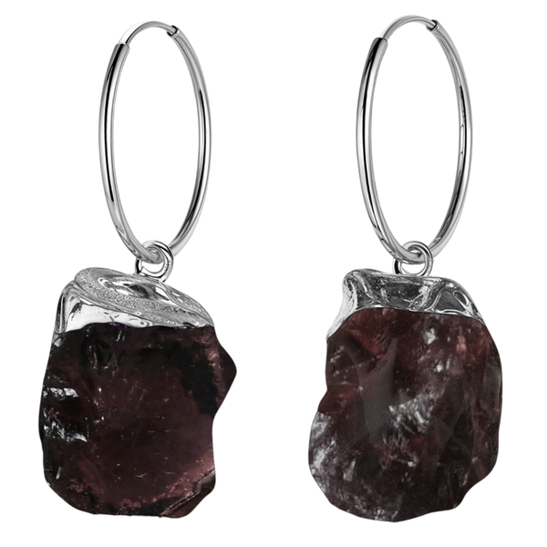 A pair of sterling silver hoop earrings with dangling, rough-cut, organic-shaped garnet gemstones on a plain white background.