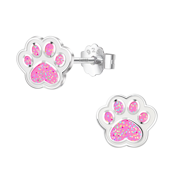 A pair of paw print stud earrings with glittery pink enamel inlay, crafted in sterling silver with push-back closures on a white background.