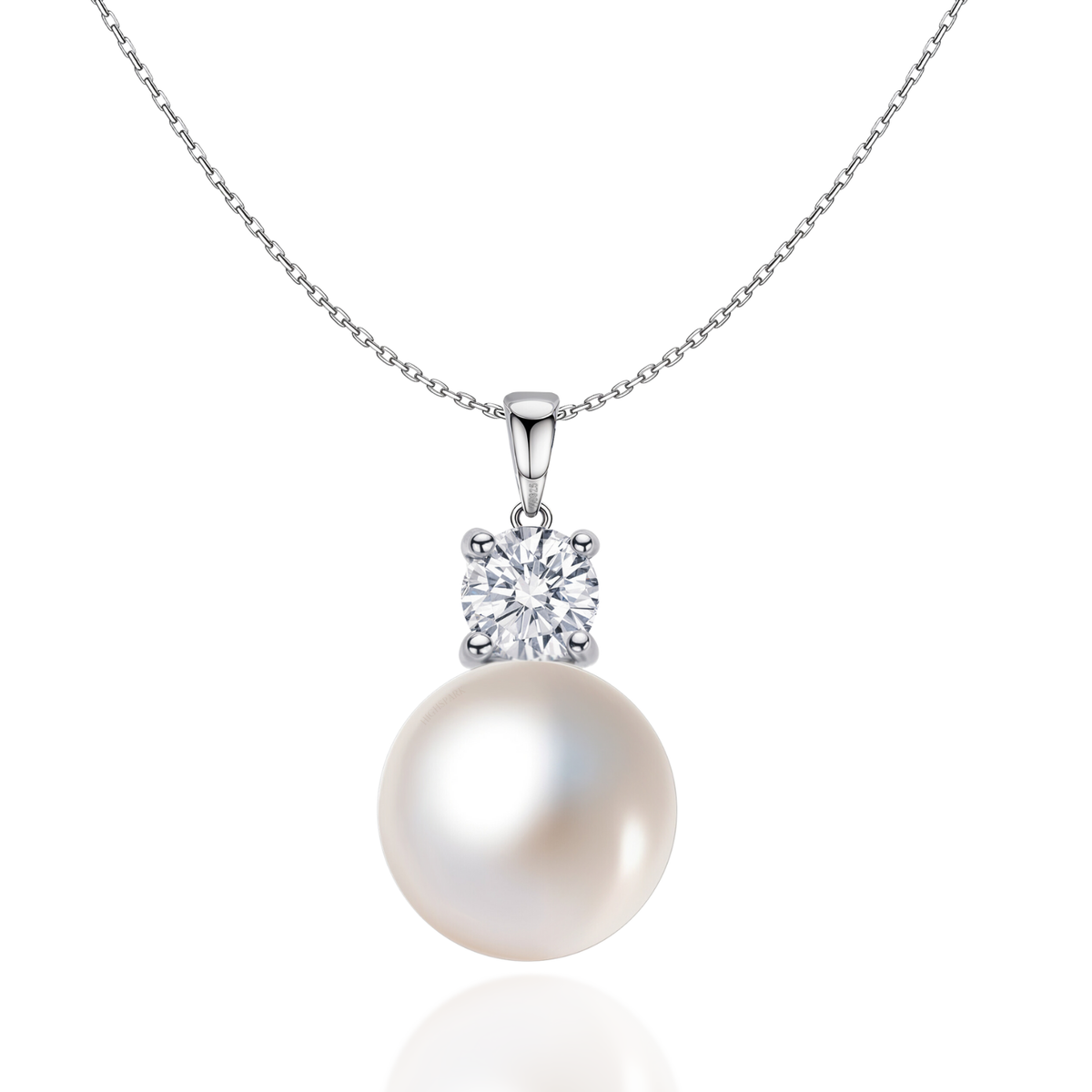 A sterling silver pendant necklace with a large white pearl topped by a round American diamond in a four-prong setting on a white.