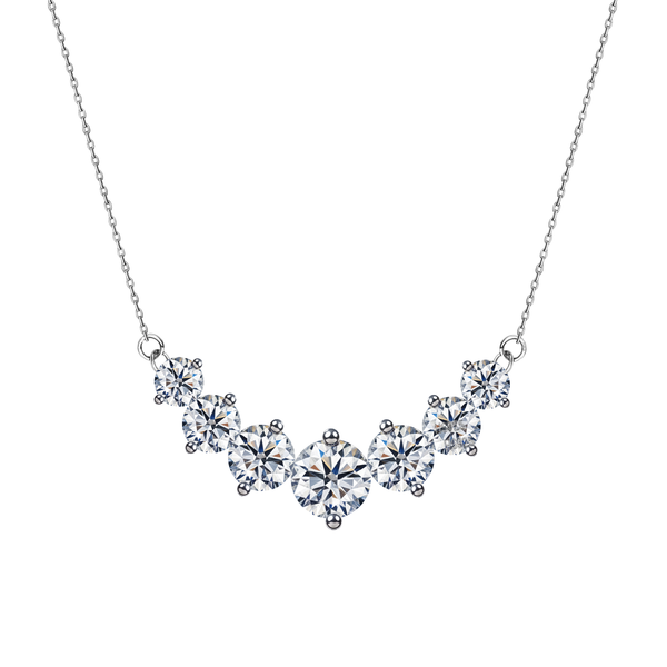 A sterling silver pendant necklace with seven graduated, round American diamonds in a curved bar setting on a plain white background.