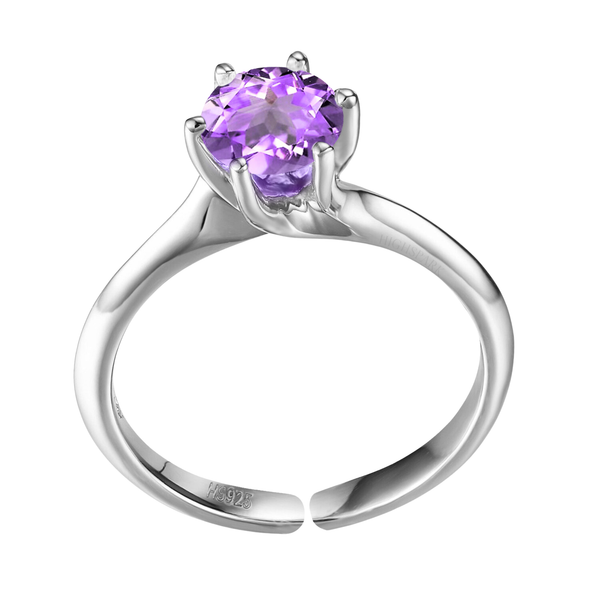 An adjustable sterling silver solitaire ring with a round, faceted amethyst gemstone held in a six-prong setting on a plain white.