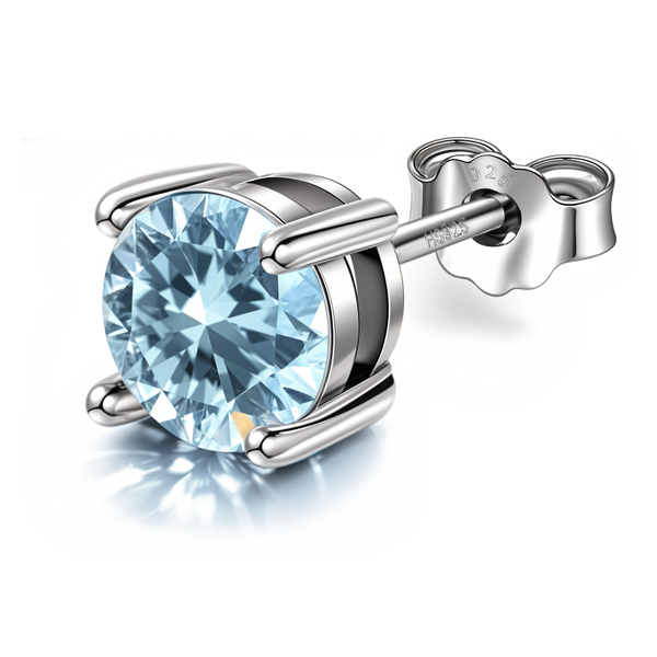 A solitaire stud earring with a round, light blue aquamarine American diamond in a four-prong sterling silver setting on a white background.