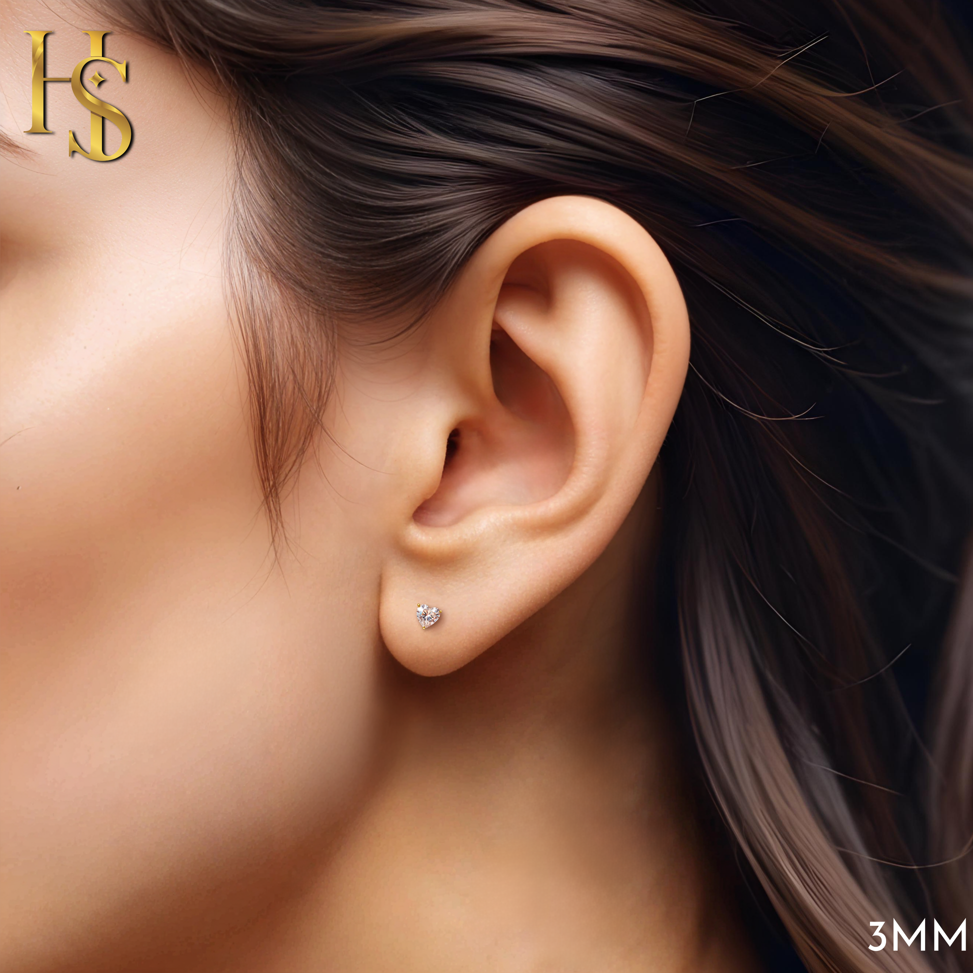 A tiny, heart-shaped American diamond stud earring in a gold-plated sterling silver prong setting, worn on the earlobe.