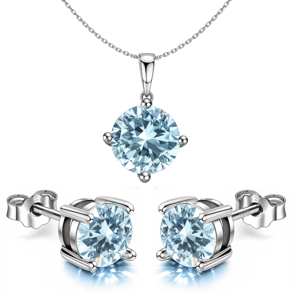 A pendant and stud earring set with round, light blue aquamarine stones in a four-prong setting.