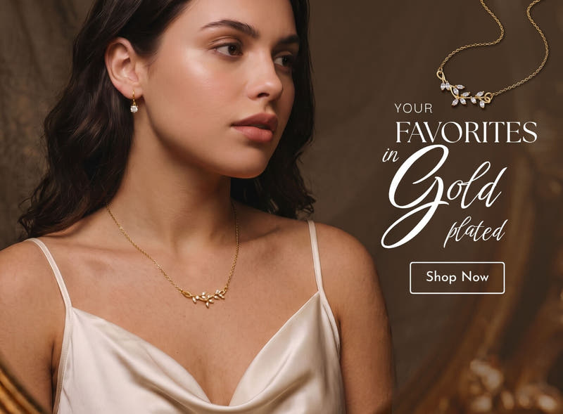 Gold-plated silver jewellery - woman wearing an 18k gold-finish leaf necklace and solitaire drop earrings, reflected in a gilded mirror