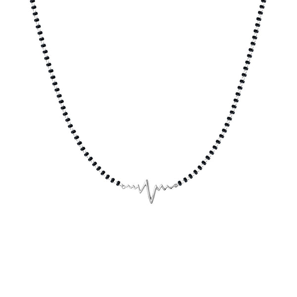 A sterling silver mangalsutra necklace with a central heartbeat motif on a traditional black beaded chain, shown on a white background.