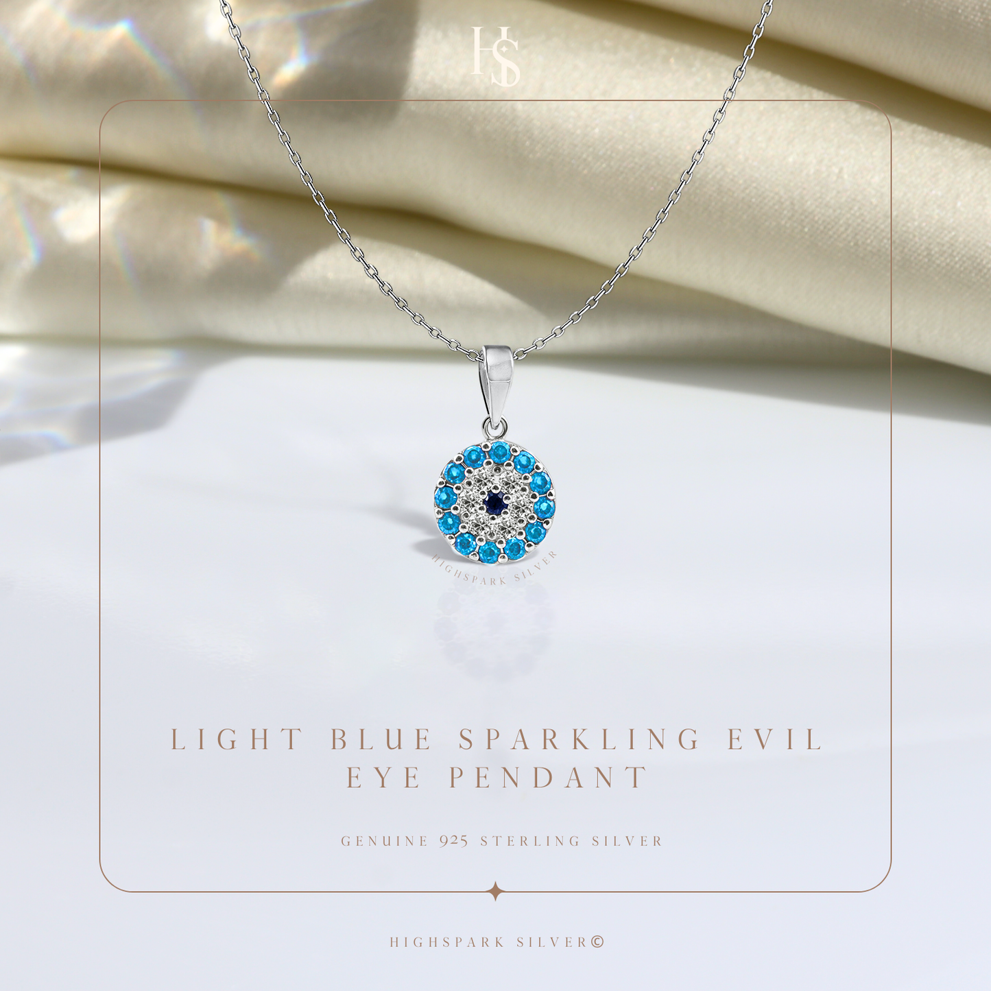 A sterling silver evil eye pendant necklace with light blue and dark blue stones in a halo setting.