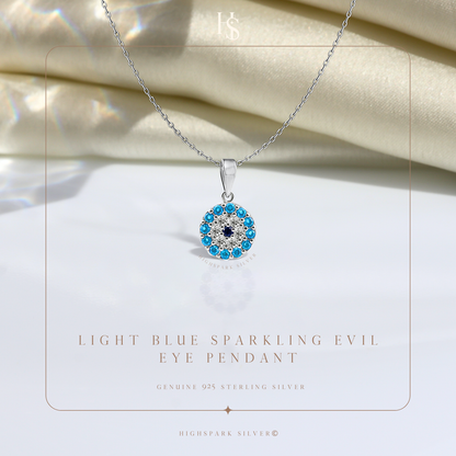 A sterling silver evil eye pendant necklace with light blue and dark blue stones in a halo setting.