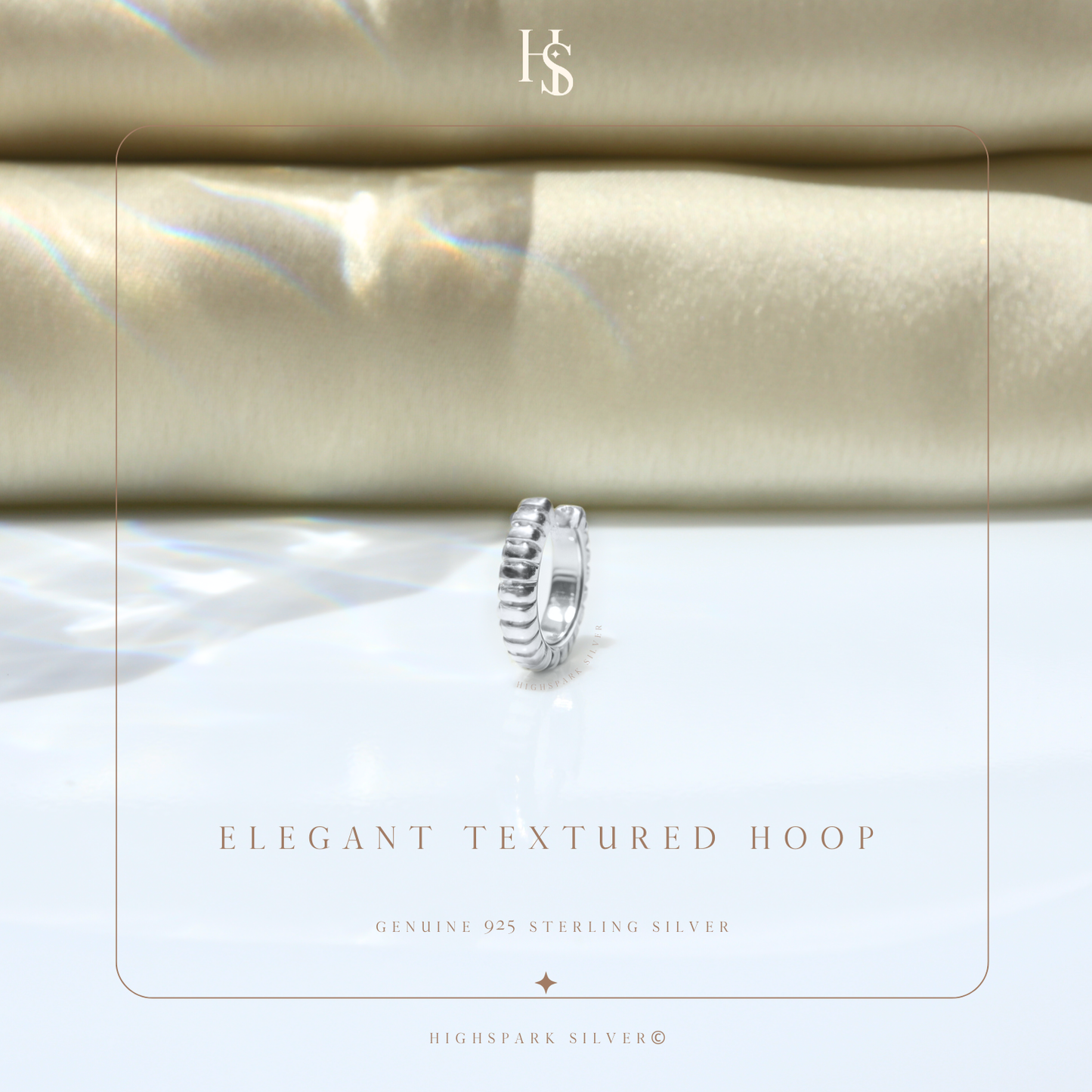 A single sterling silver huggie hoop earring with a ribbed texture.