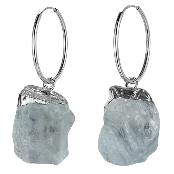 A pair of hoop earrings with raw, uncut aquamarine gemstone charms in a sterling silver setting, shown on a white background.