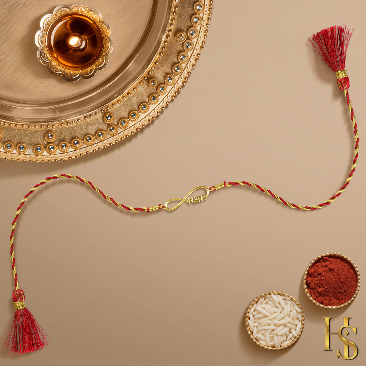 A 925 sterling silver rakhi for a brother with an 18K gold finish infinity '#BRO' motif on a twisted red and gold thread.