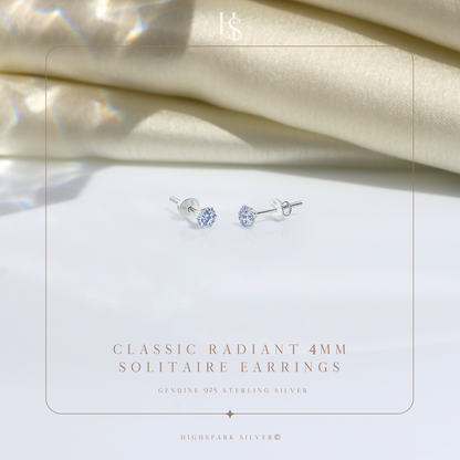 A pair of sterling silver stud earrings with round American diamonds in a four-prong setting.