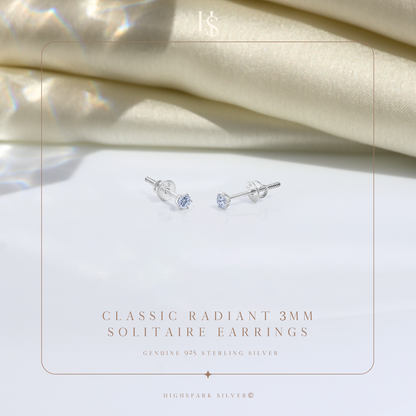 A pair of sterling silver solitaire stud earrings with round American diamonds in a four-prong setting and screw backs.