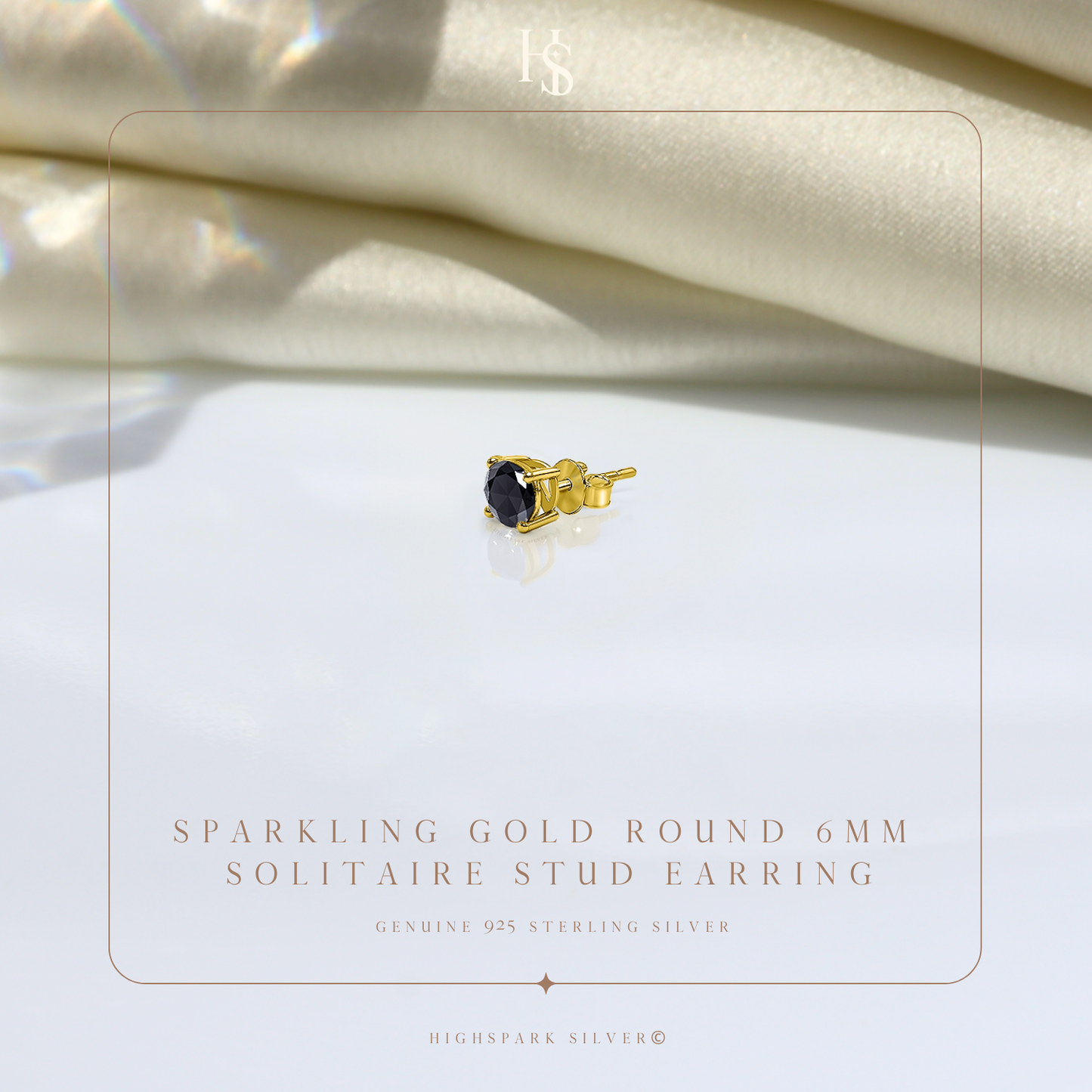 A single gold-plated stud earring with a round black stone in a four-prong setting.