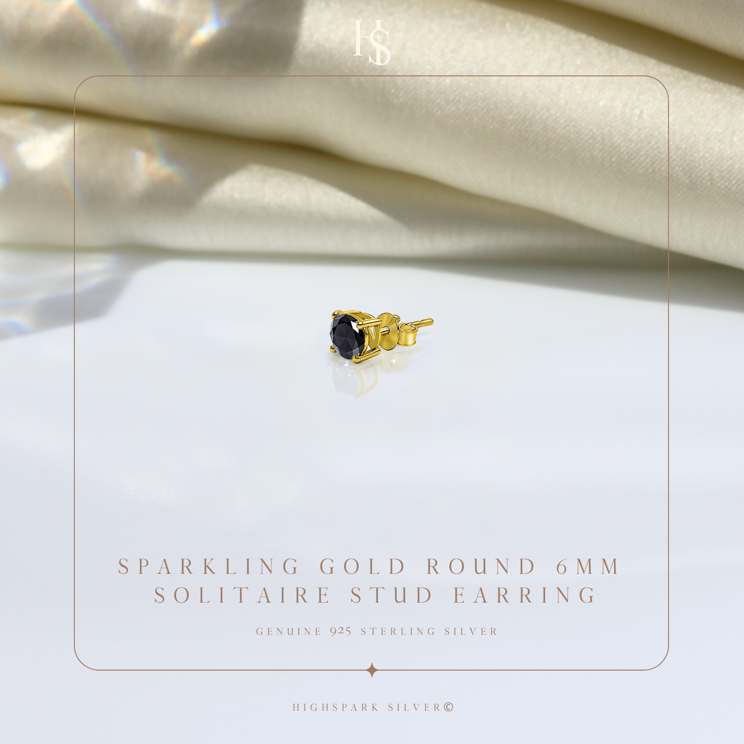 A single gold-plated stud earring with a round black stone in a four-prong setting.