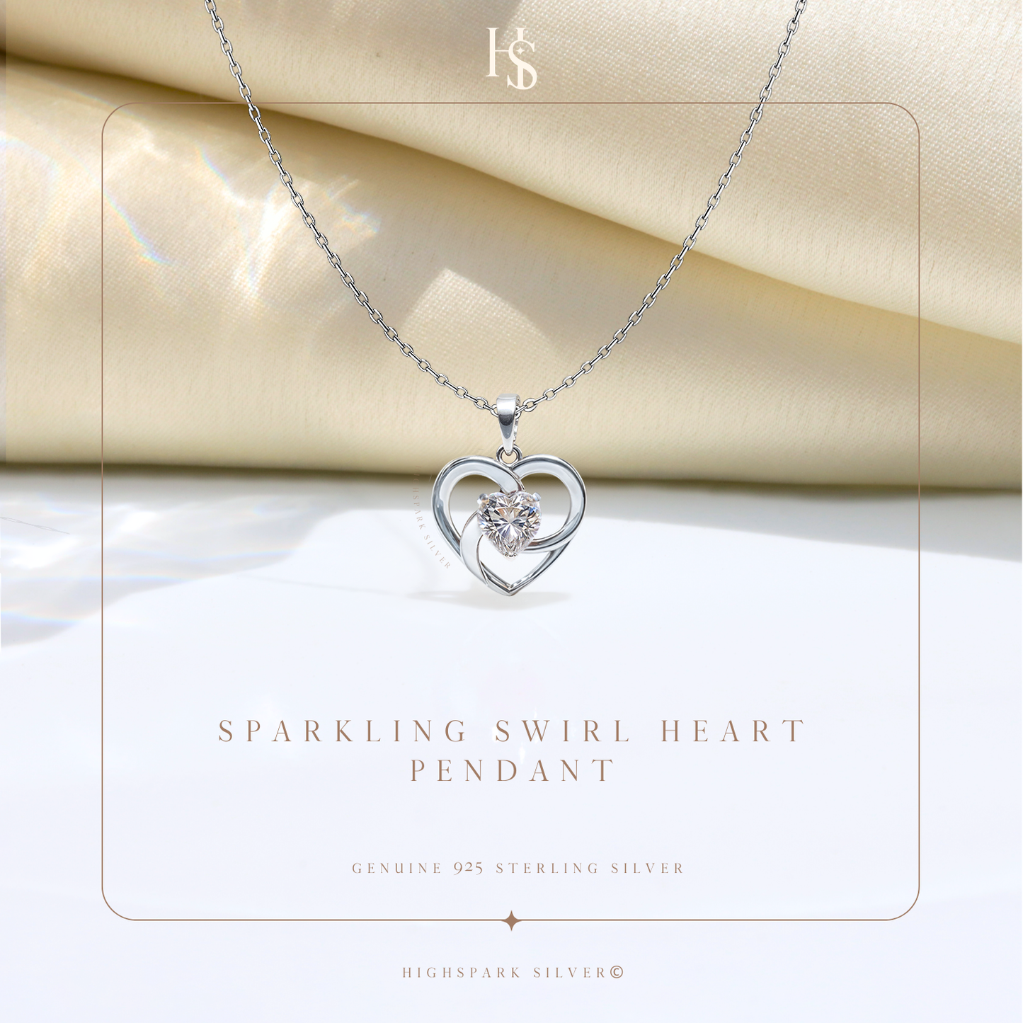 A sterling silver pendant necklace with an open heart and a central round American diamond, styled on draped cream satin fabric.