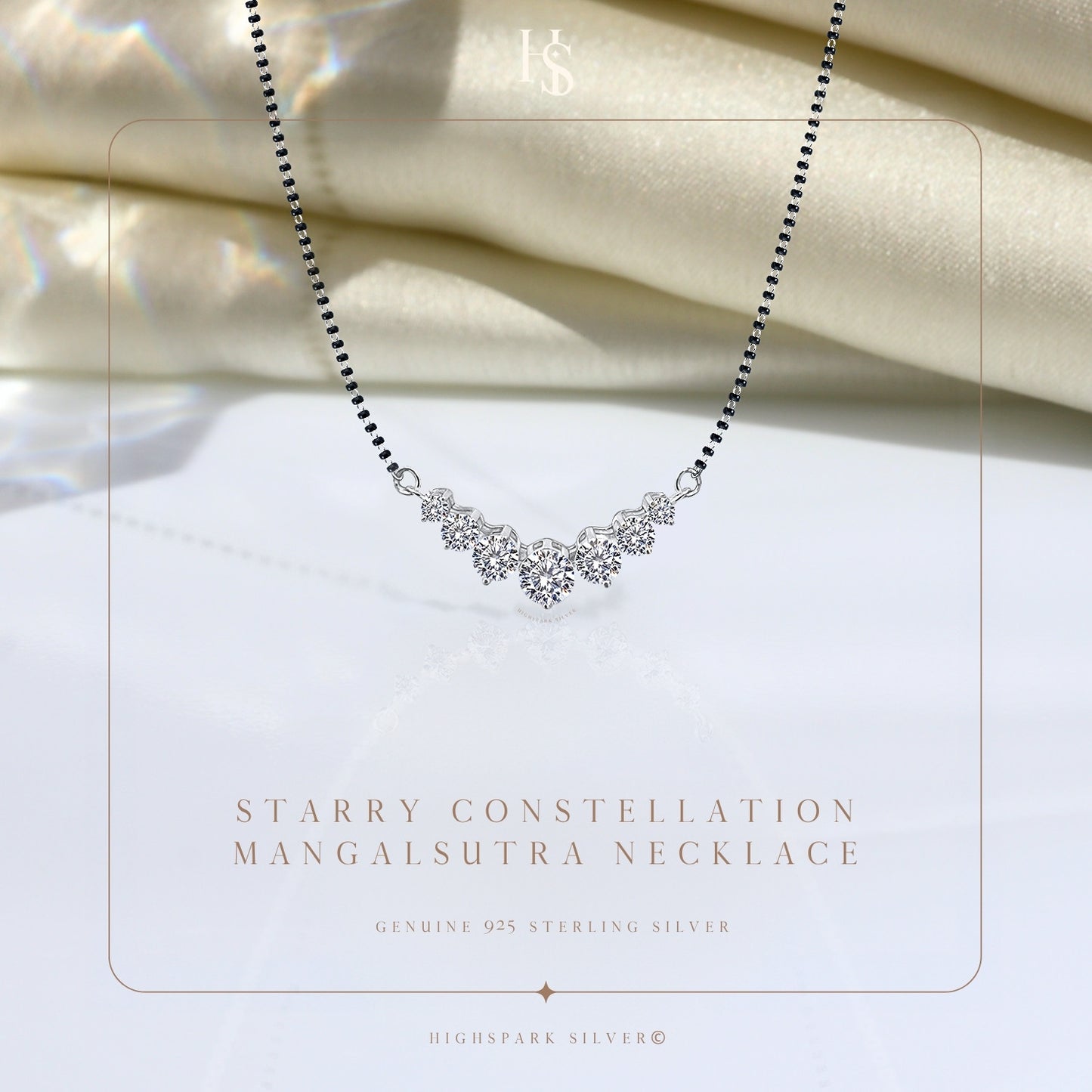 A sterling silver mangalsutra necklace with five prong-set American diamonds in a curved constellation, styled on draped ivory satin.