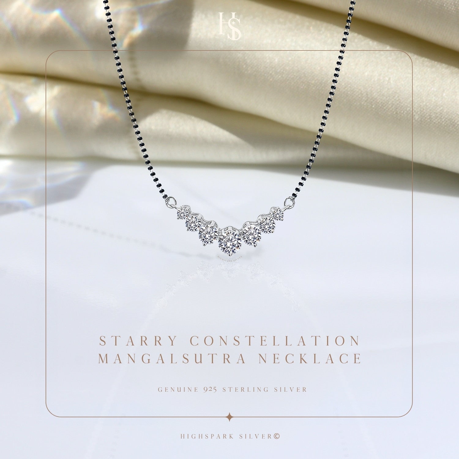 A sterling silver mangalsutra necklace with five prong-set American diamonds in a curved constellation, styled on draped ivory satin.