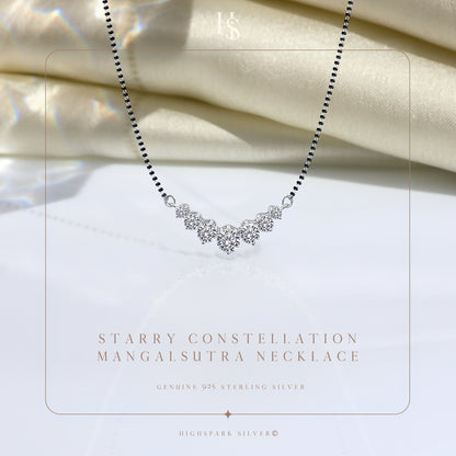 A sterling silver mangalsutra necklace with five prong-set American diamonds in a curved constellation, styled on draped ivory satin.