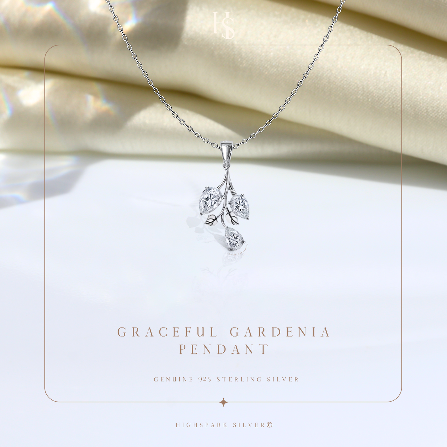 A sterling silver pendant necklace with a floral spray motif featuring three pear-cut American diamonds.