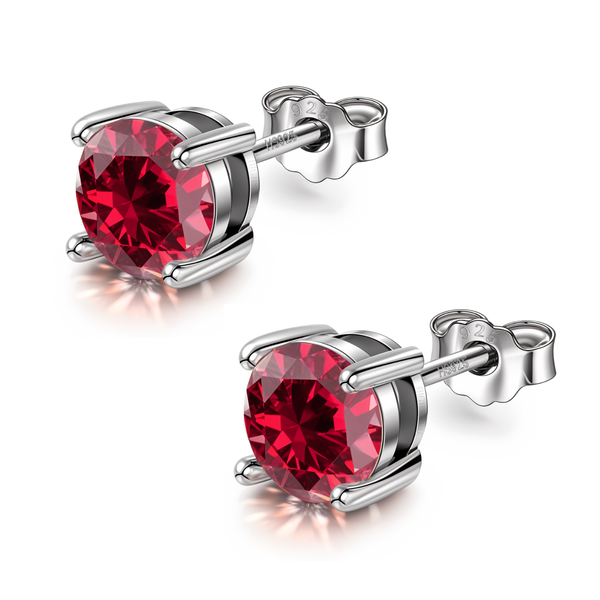 A pair of sterling silver stud earrings with round-cut ruby red American diamonds in a four-prong setting on a white background.