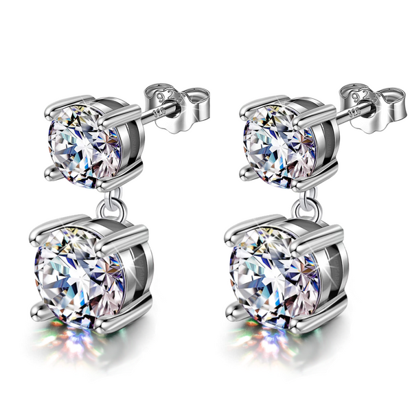 A pair of sterling silver drop earrings, each with two round American diamonds in four-prong settings, shown on a white reflective surface.