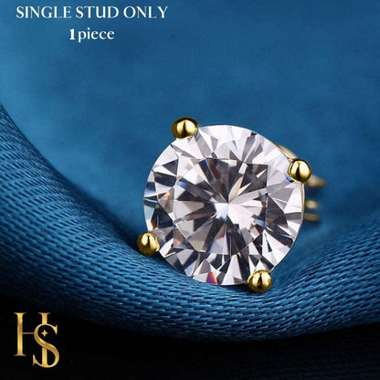 A single gold-plated stud earring with a round American diamond in a four-prong setting, styled on a piece of blue satin fabric.