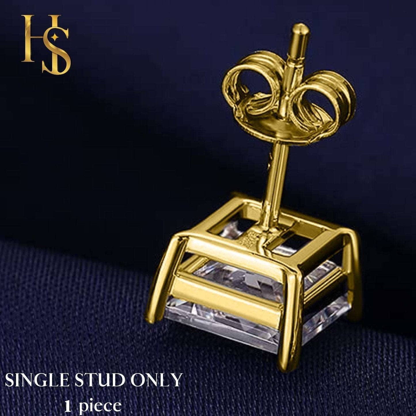 A single gold-plated stud earring with a square American diamond in a four-prong setting, shown from the back on a dark blue fabric.