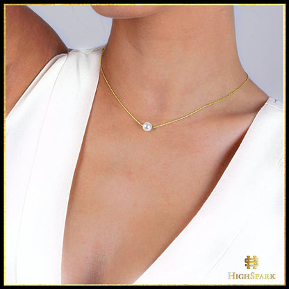 A delicate solitaire pearl pendant on a thin, gold-plated sterling silver chain worn on a model's neck.