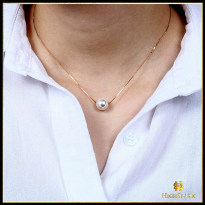 A single white pearl pendant necklace on a delicate rose gold-plated sterling silver chain, worn on the neck with a white collared shirt.